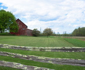 rural farm field with red barn with fence
