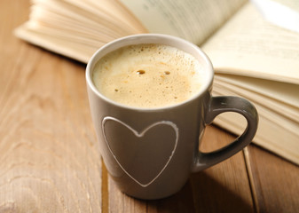 Still life with cup of coffee and book, on wooden table