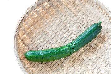 Fresh green cucumber in bamboo tray on white background