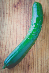 Fresh green cucumber on wood chopping block background