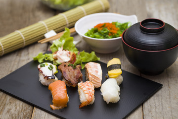 Sushi assortment on black dish, close up