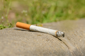 Cigarette on asphalt