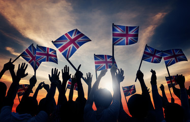 Group of People Waving UK Flags in Back Lit