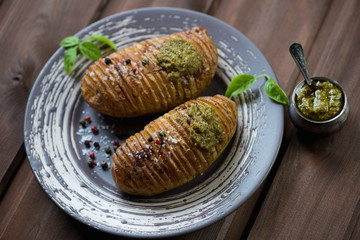 Baked hasselback potatoes with fresh basil pesto sauce