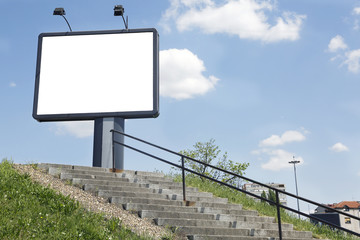 Empty white ad billboard near stairs