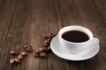 Cup of hot coffee on a wooden table. Coffee beans.