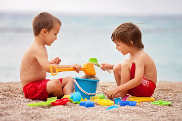 Two cute kids, playing in the sand on the beach