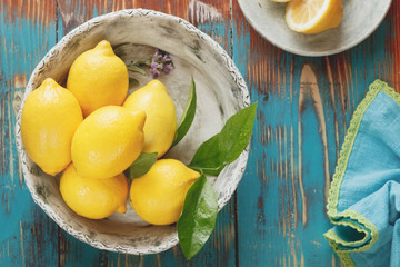 Lemons. Fresh lemons with leaves in  rustic ceramic bowl