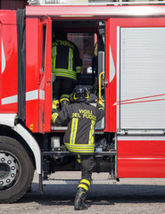 Italian firefighters climb on the trucks of firefighters