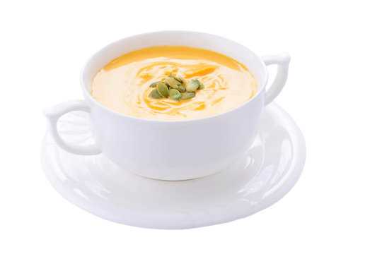 Pumpkin cream soup in bowl on white background