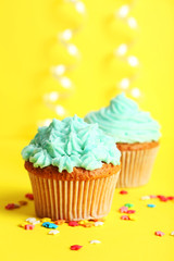 Birthday cupcake with butter cream on yellow background