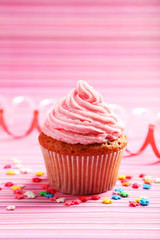 Birthday cupcake with butter cream on colorful background