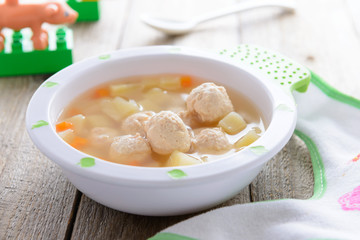 Child food: soup with potatoes and chicken meatballs