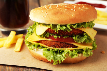 Big burger on brown wooden background