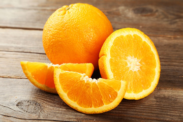 Orange fruit and glass of juice on brown wooden background