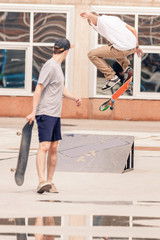handsome guys riding by skateboard at freestyle park outdoors