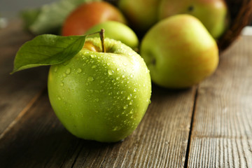 Green apple with leaf on brown wooden background