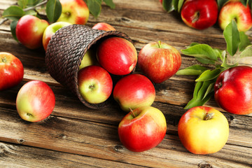 Apples in basket on brown wooden background