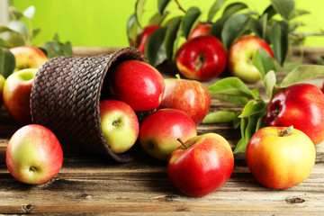 Naklejka na ściany i meble Apples in basket on brown wooden background