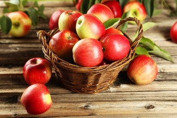 Fototapeta na wymiar Apples in basket on brown wooden background