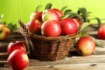 Fototapeta na wymiar Apples in basket on brown wooden background