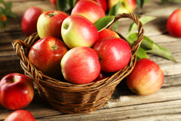 Naklejka na ściany i meble Apples in basket on brown wooden background