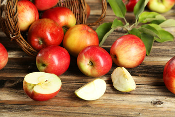 Apples in basket on brown wooden background