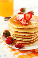 Delicious pancakes with strawberry on white wooden background