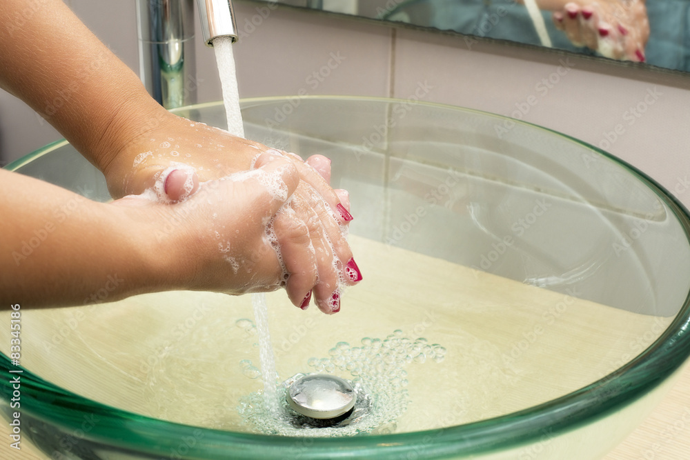 Wall mural Hands washing with soap under running water