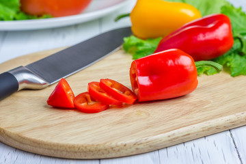 Sliced red paprika on the wooden board, closeup