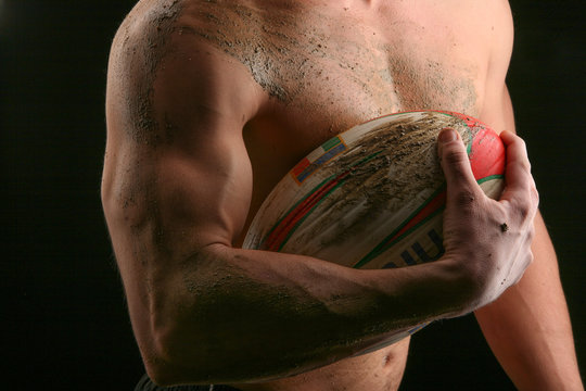 Atleta a torso nudo con pallone da rugby 