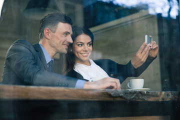 Couple making selfie photo on smartphone in cafe