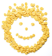 Cornflakes arranged as smiley face on a white background.