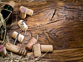 Wine bottle and corks on an old wooden table.