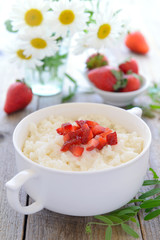 Rice pudding with slices of strawberry - tasty breakfast