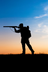 Fototapeta na wymiar Hunter with shotgun in sunset