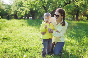 Fototapeta premium Toddler boy and his mom making with before blowing dandelion