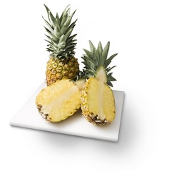 Naklejka na ściany i meble Pineapples on cutting board isolated on white