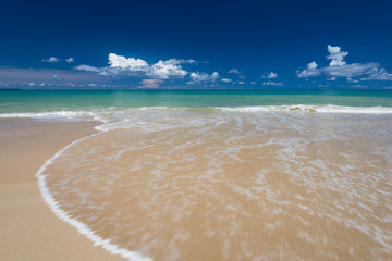 sea waves lash line impact on the sand beach under blue sky
