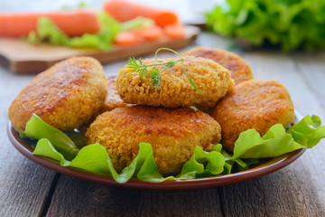 Dietetic carrots cutlets on wooden table