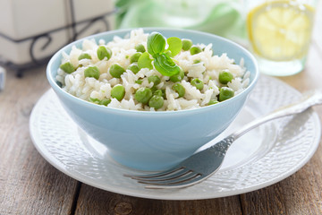Risotto with green peas in blue bowl