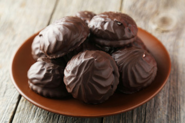 Zephyr in chocolate on plate on grey wooden background