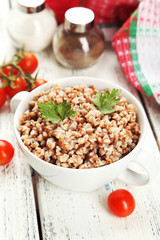 Buckwheat in bowl on white wooden background