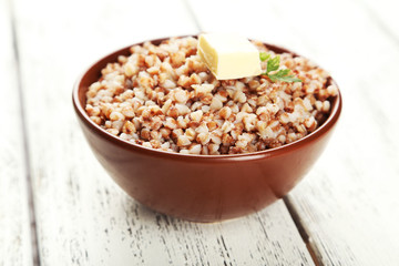 Buckwheat in bowl on white wooden background