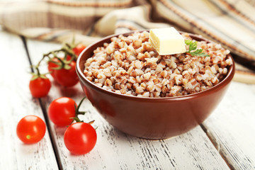 Buckwheat in bowl on white wooden background