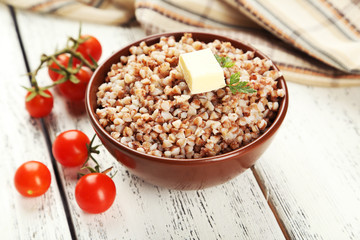 Buckwheat in bowl on white wooden background