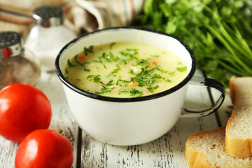 Cup of soup on white wooden background