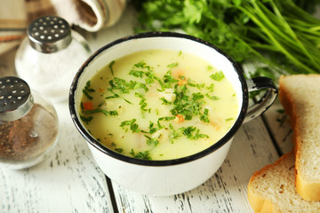 Cup of soup on white wooden background