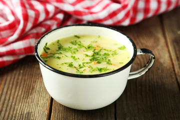 Cup of soup on brown wooden background