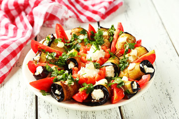 Tasty eggplant rolls on white wooden background